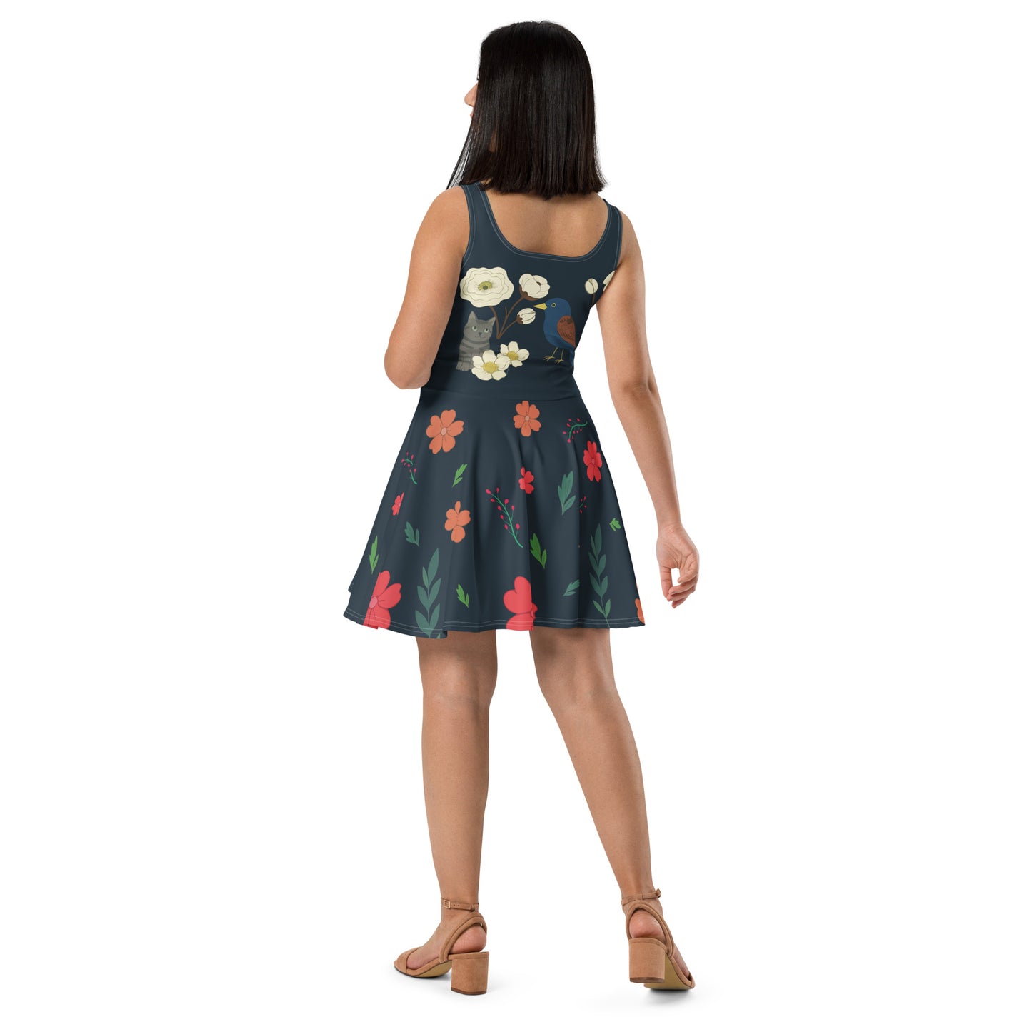 Jeune femme portant une robe patineuse bleu marine à fleurs, oiseaux et chat dessiné